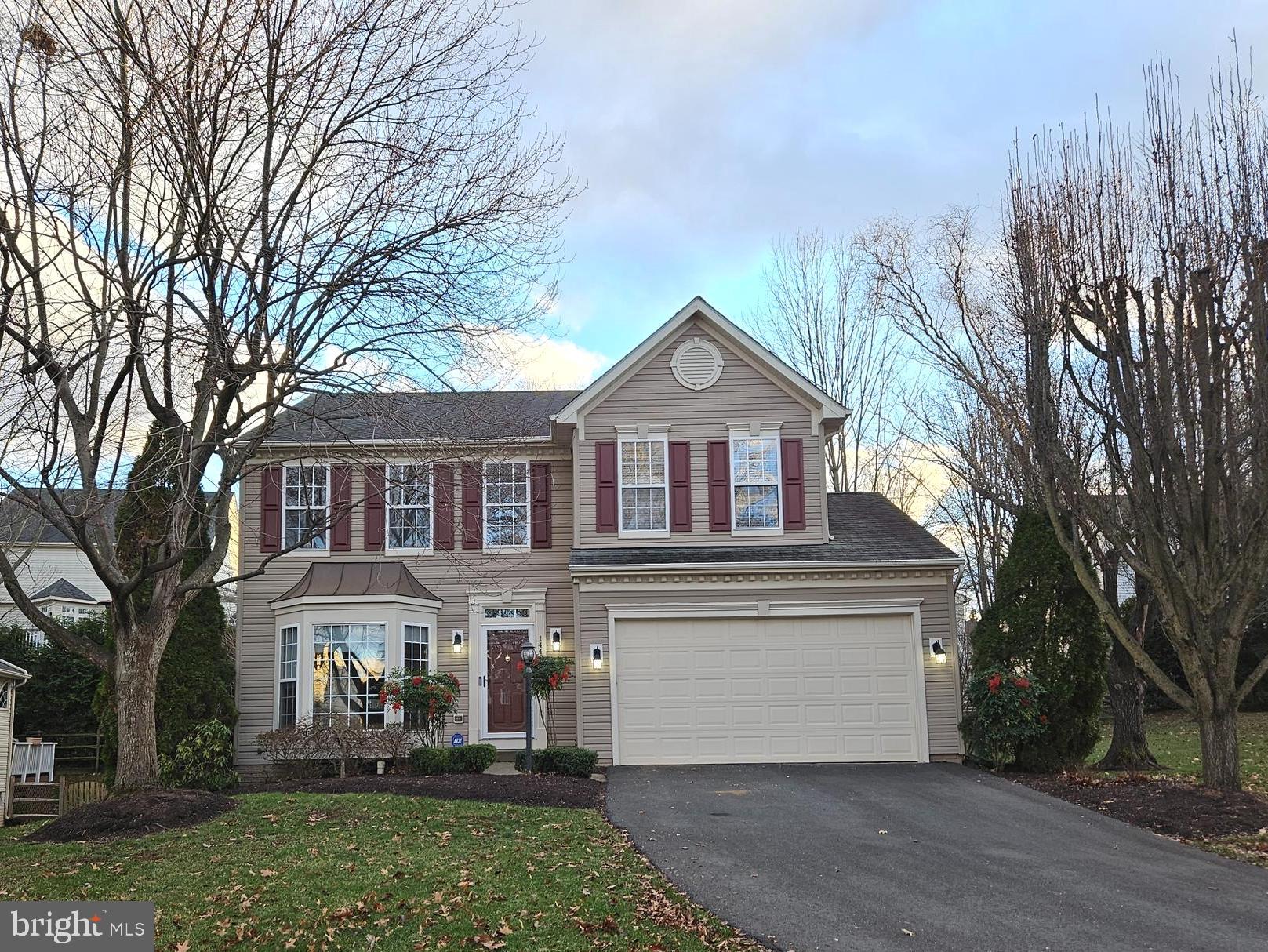 a front view of a house with a yard and trees