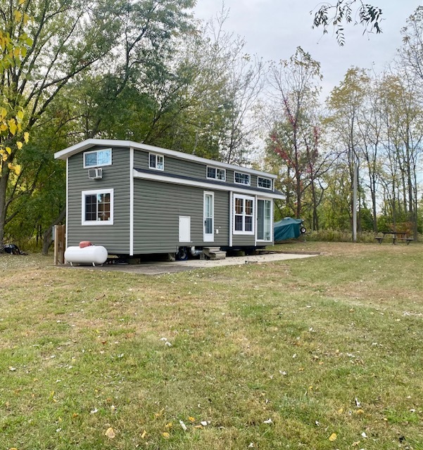 a front view of house with yard and trees in the background