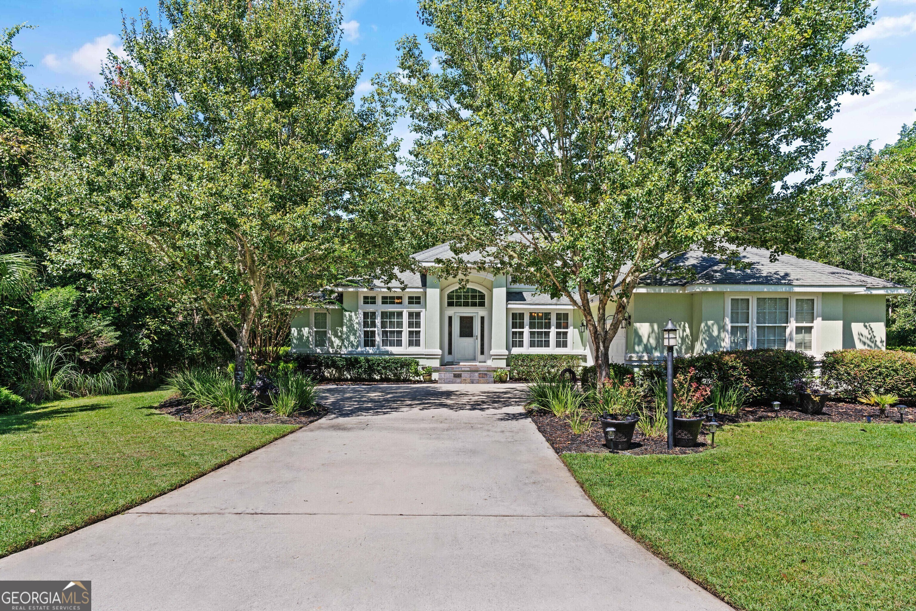 a front view of a house with a garden