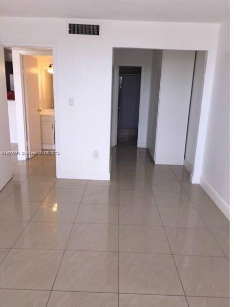 a view of a hallway with wooden floor and a bathroom