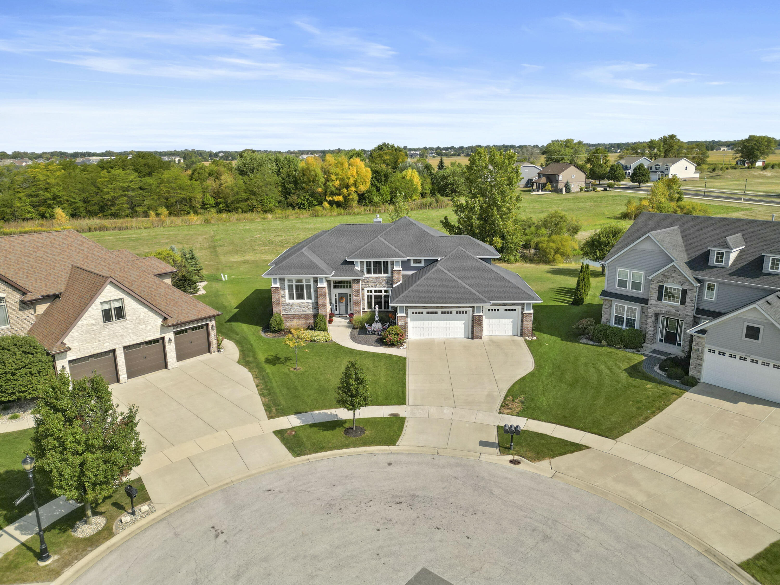 an aerial view of a house with big yard and large tree