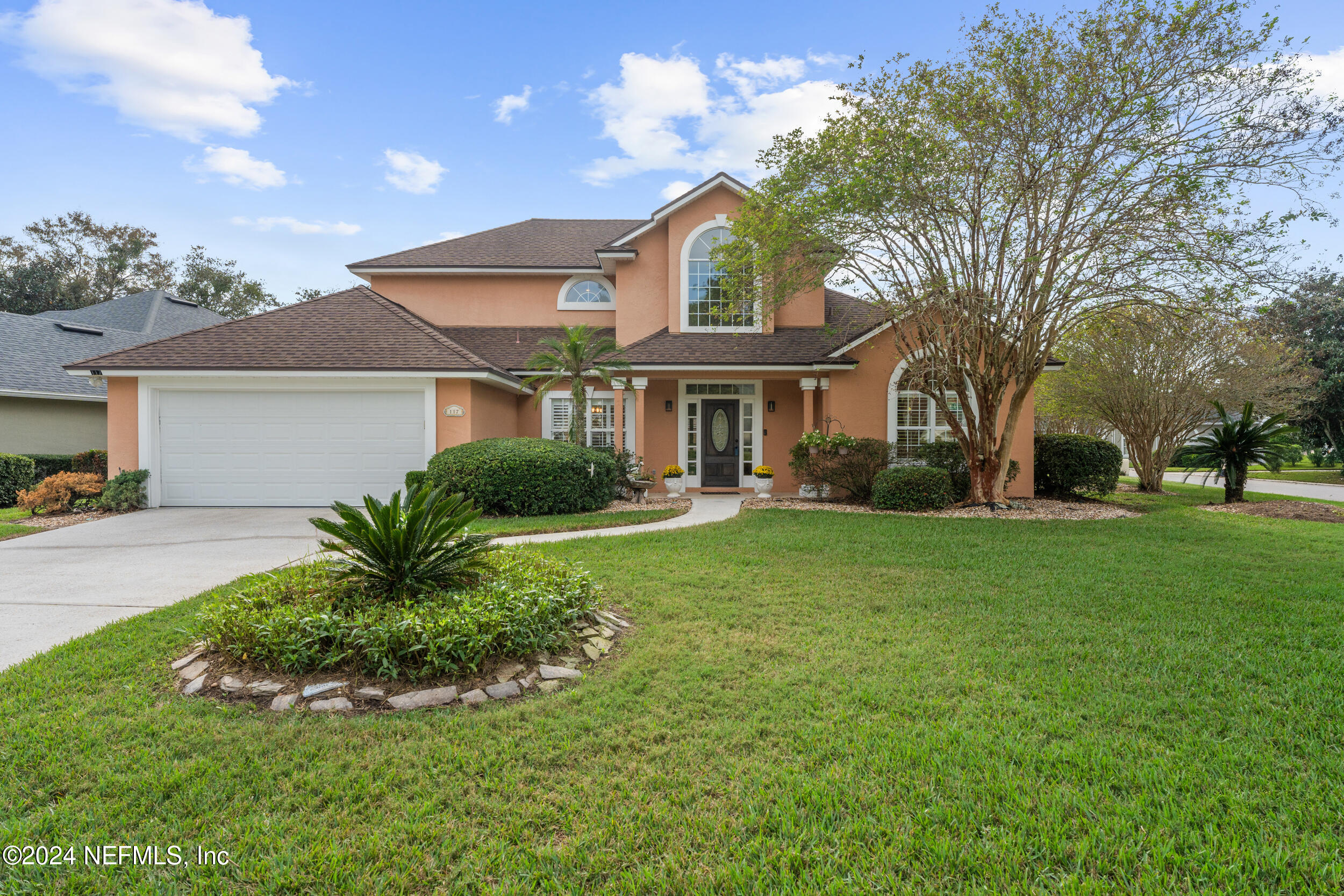 a front view of a house with a garden