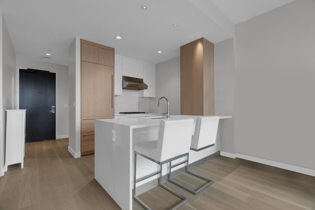 a kitchen with kitchen island a counter top space cabinets and stainless steel appliances