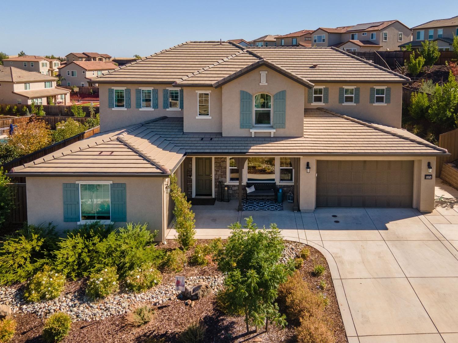 a aerial view of a house with a yard and potted plants