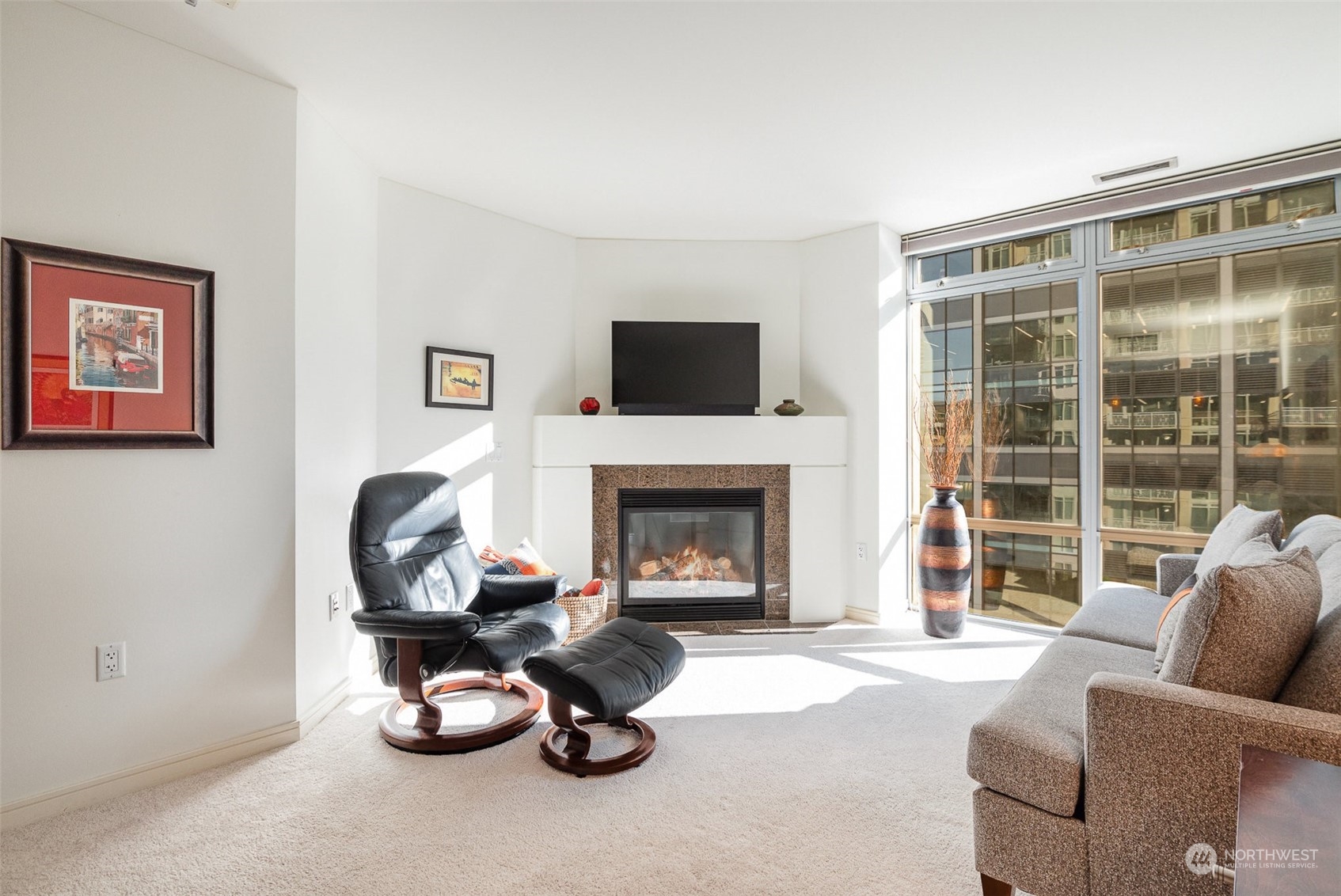 a living room with furniture a fireplace and a large window