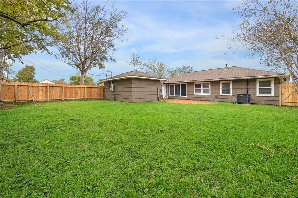 a view of a house next to a big yard and large trees