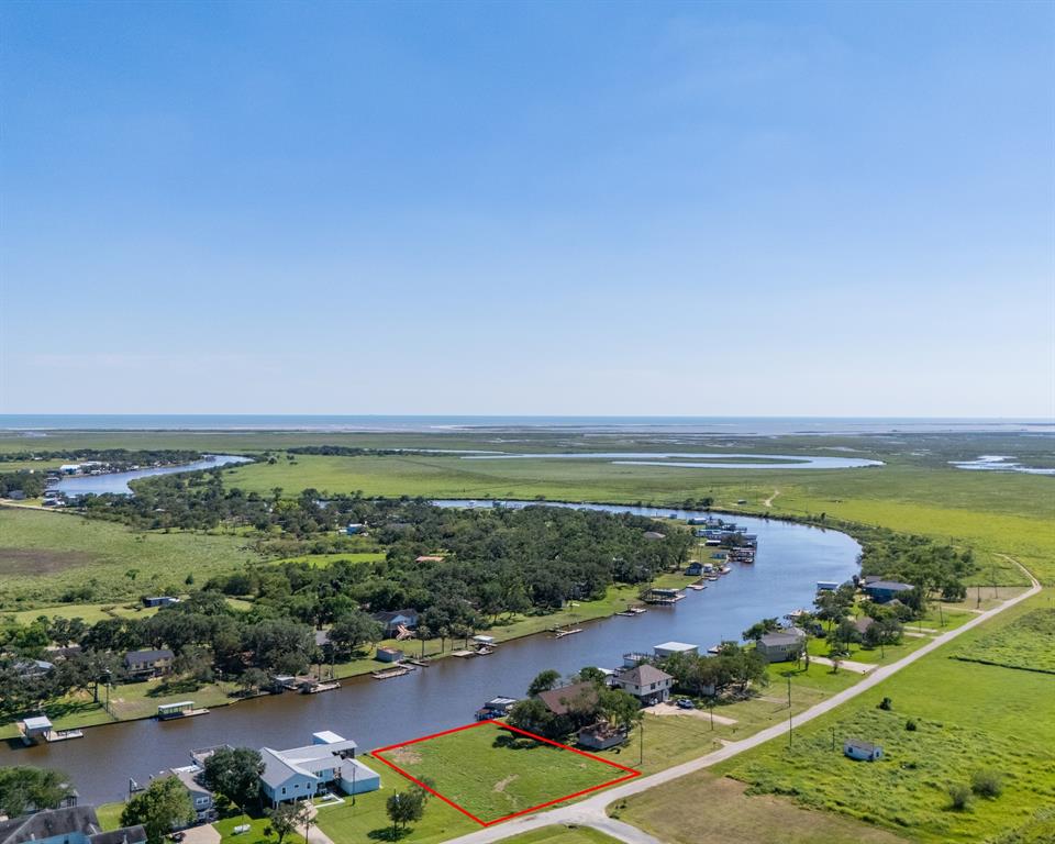 an aerial view of ocean and residential houses with outdoor space