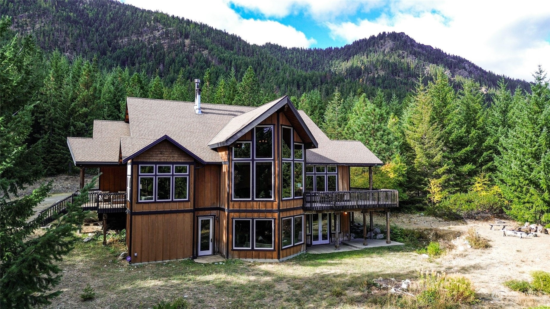 a view of a house with a yard balcony and wooden fence