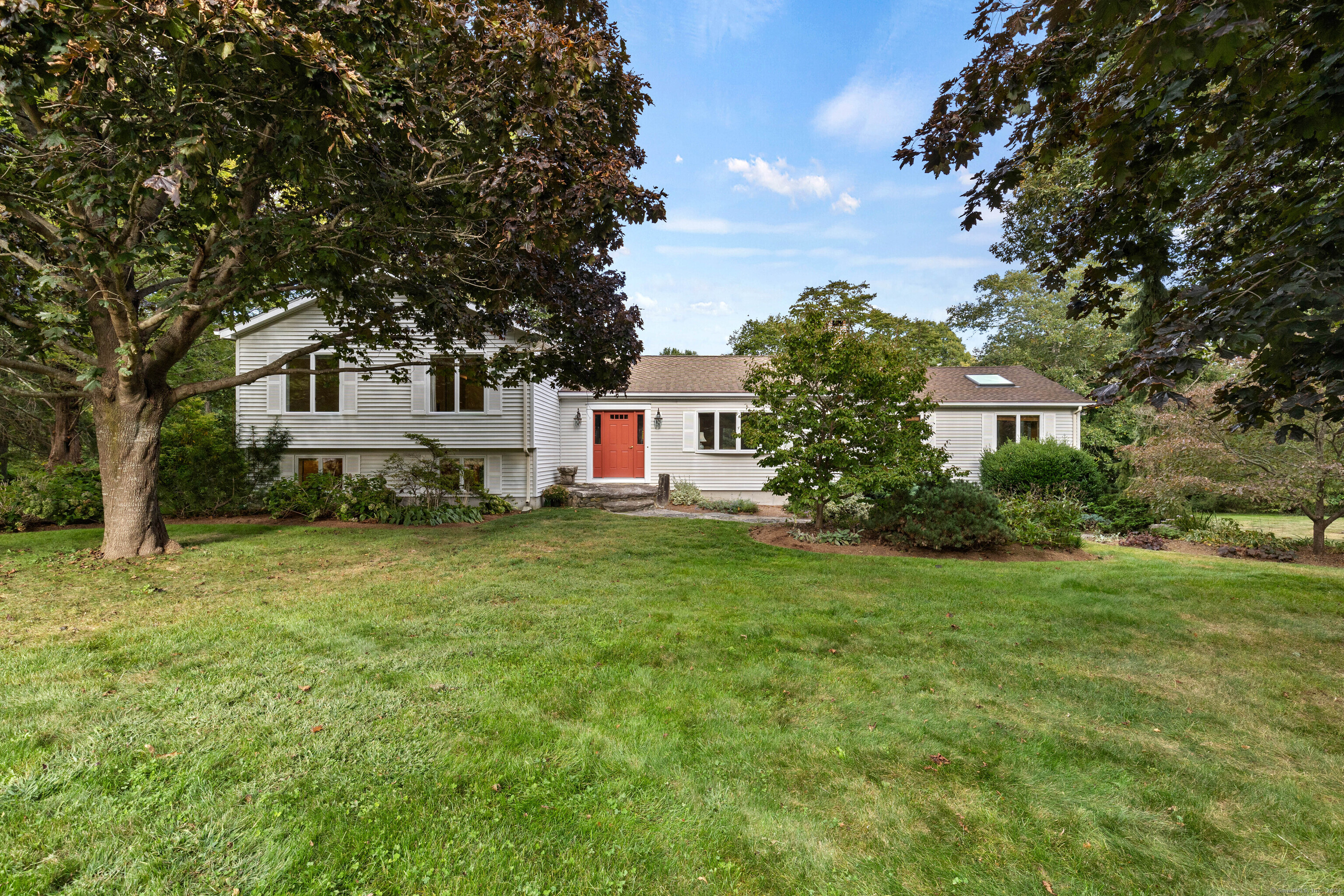 a front view of a house with a yard and trees