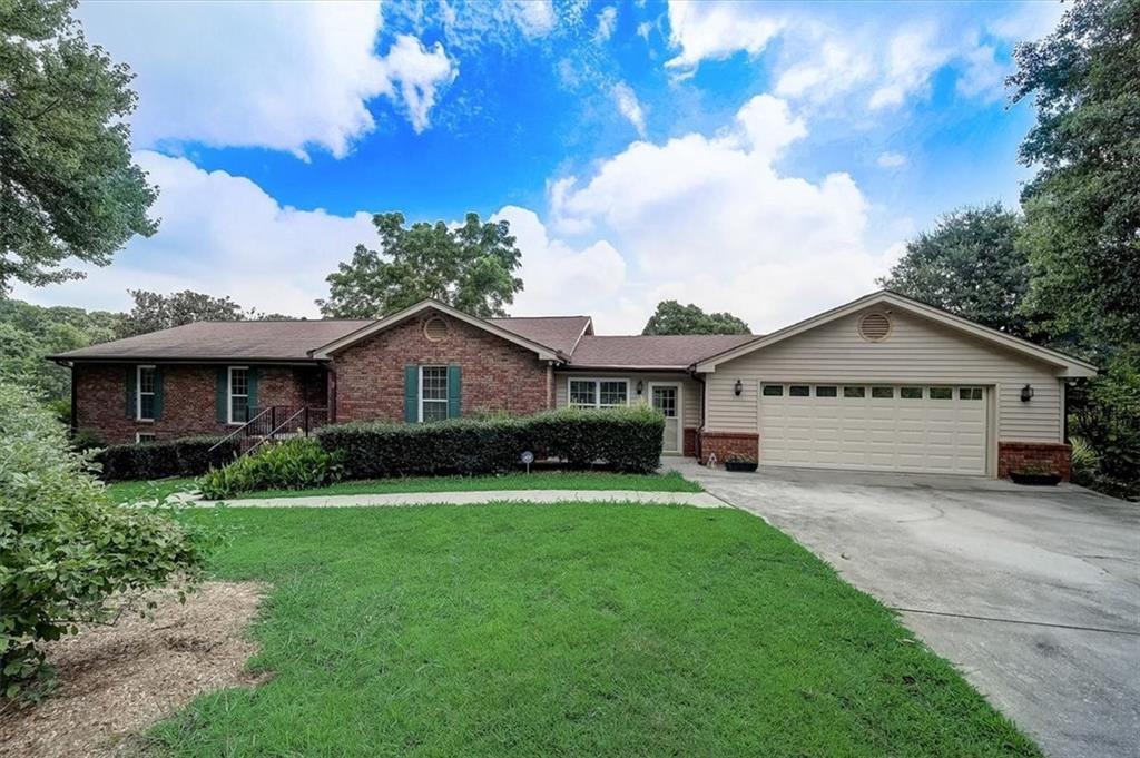 a front view of a house with yard and green space