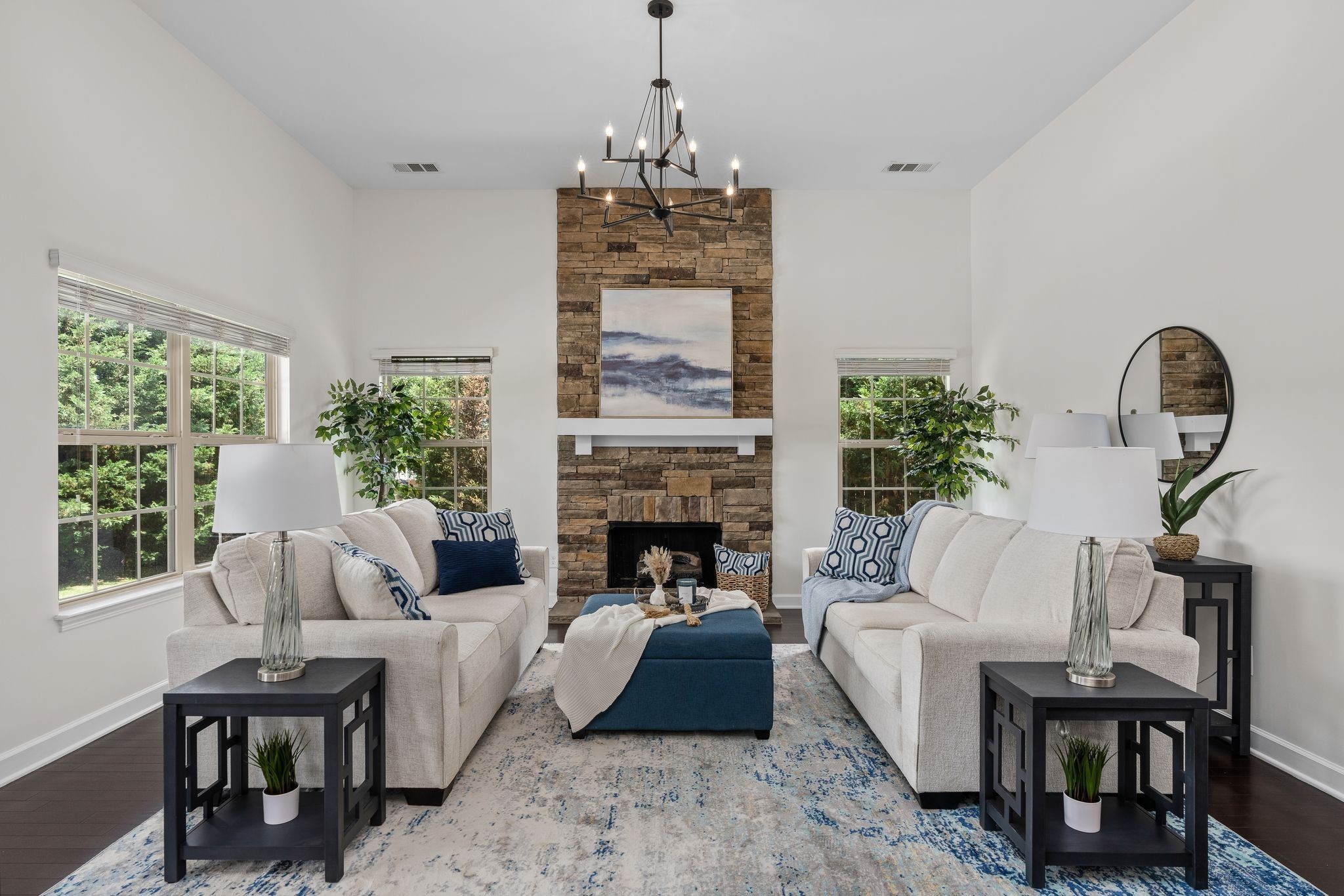 a living room with furniture a fireplace and potted plants