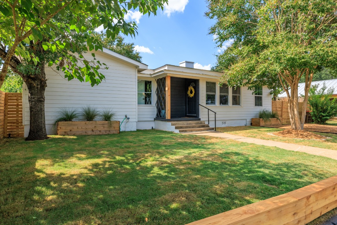 a front view of a house with a yard and trees