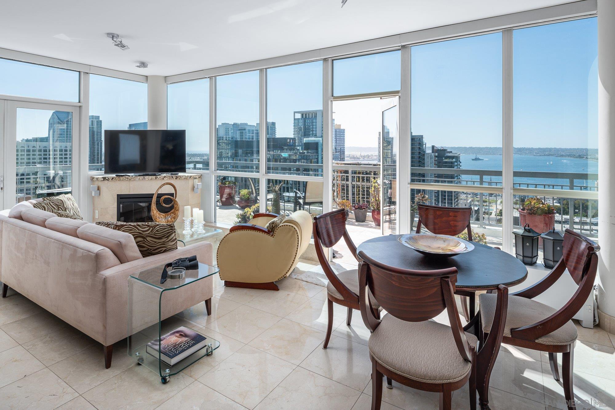 a living room with furniture a flat screen tv and a floor to ceiling window