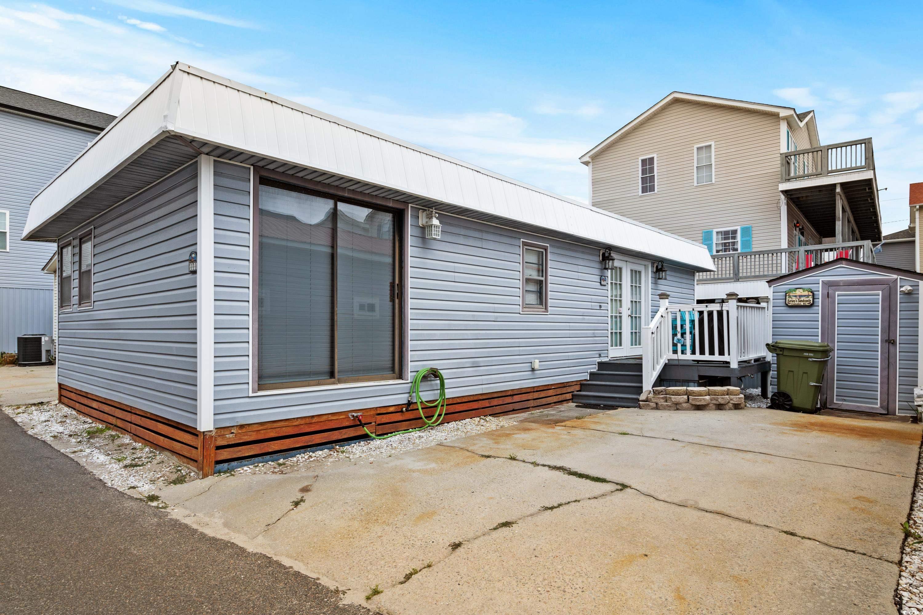 Rear view of house with cooling unit, a storage sh