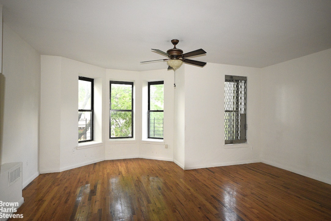 a view of a bedroom with a bed and a window