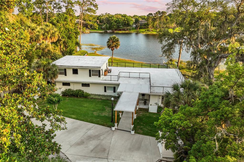 an aerial view of a house with garden space and a lake view