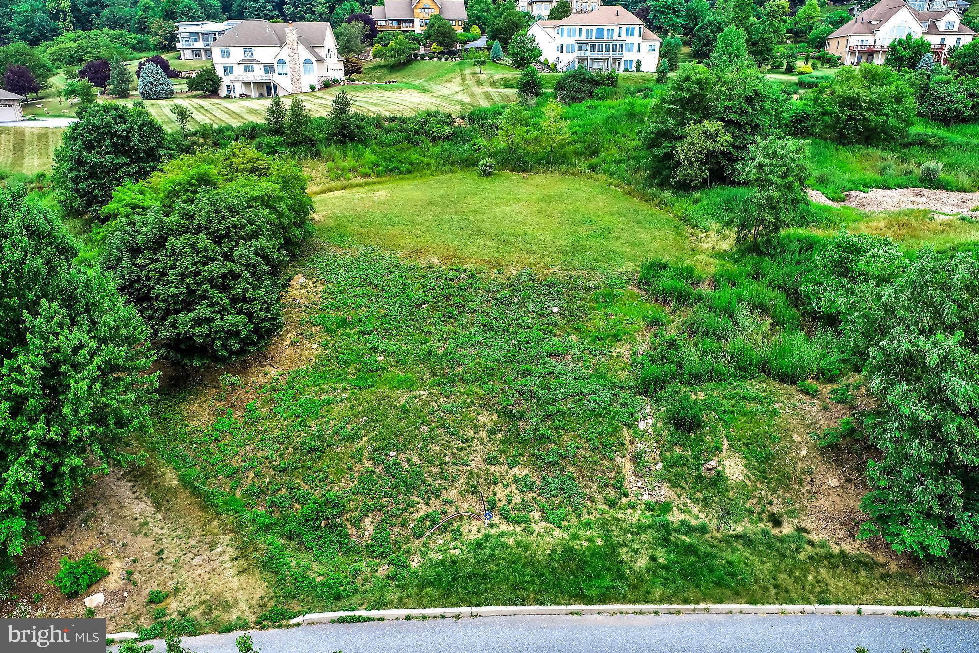 an aerial view of residential house with outdoor space and trees all around