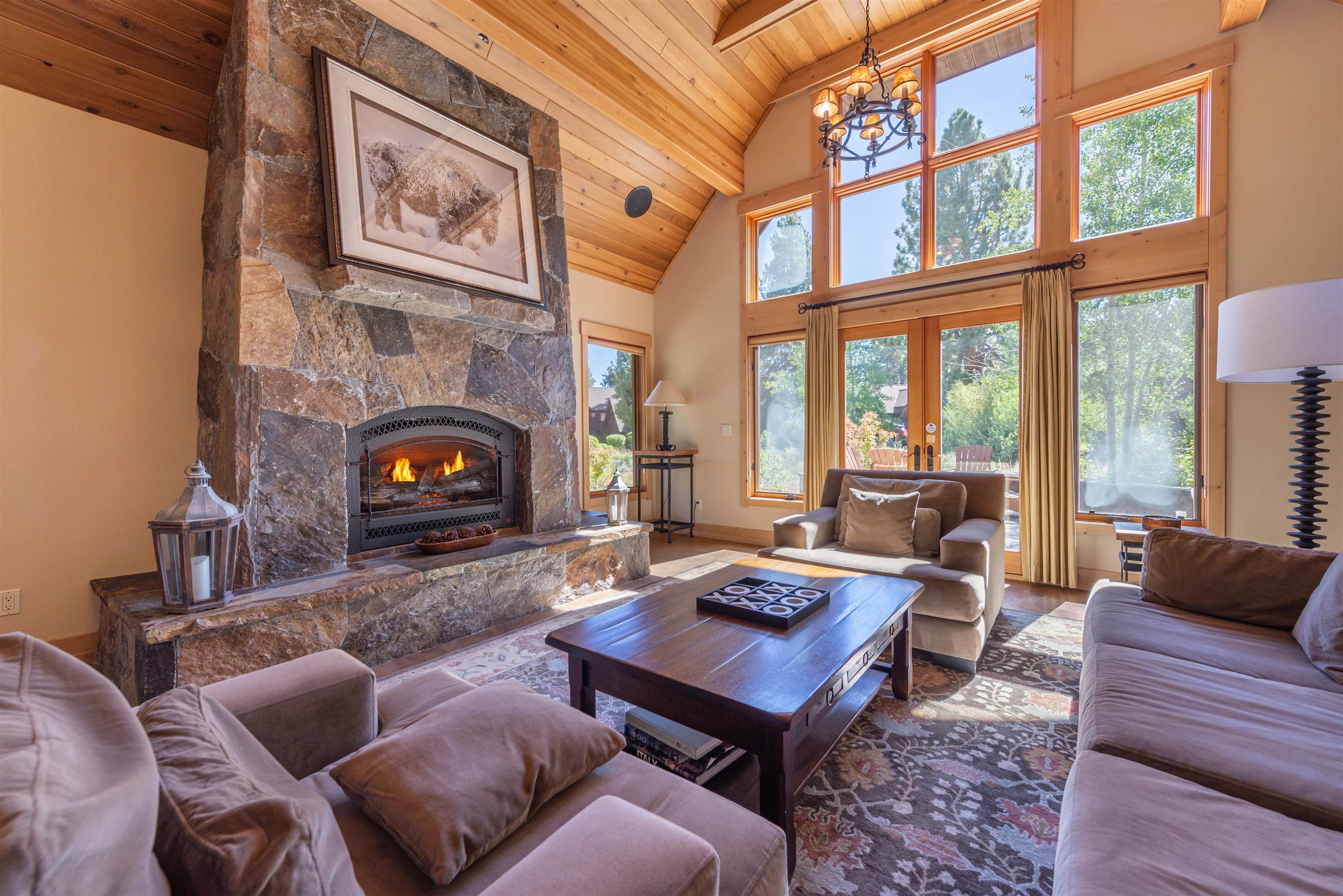 a living room with furniture a fireplace and large windows