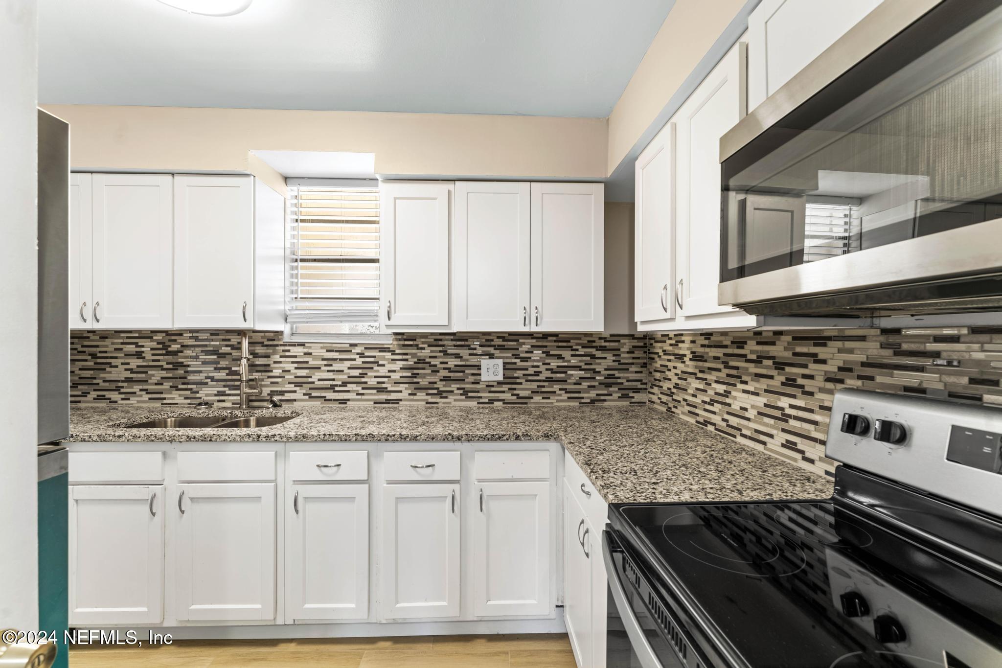 a kitchen with granite countertop a stove and a sink