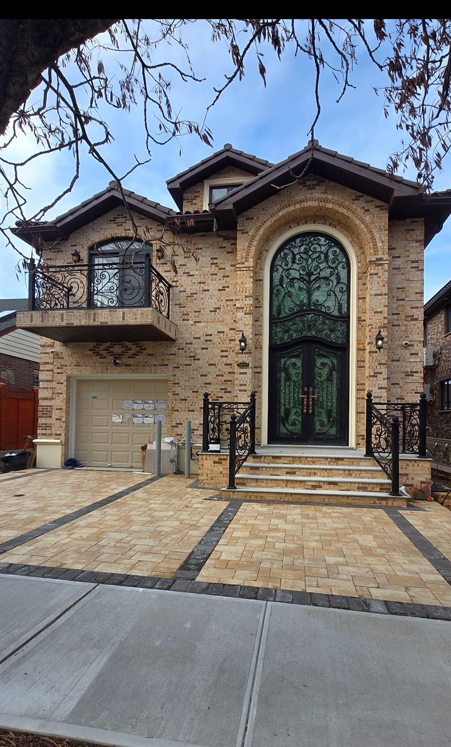 Entrance to property featuring french doors, a balcony, and a garage