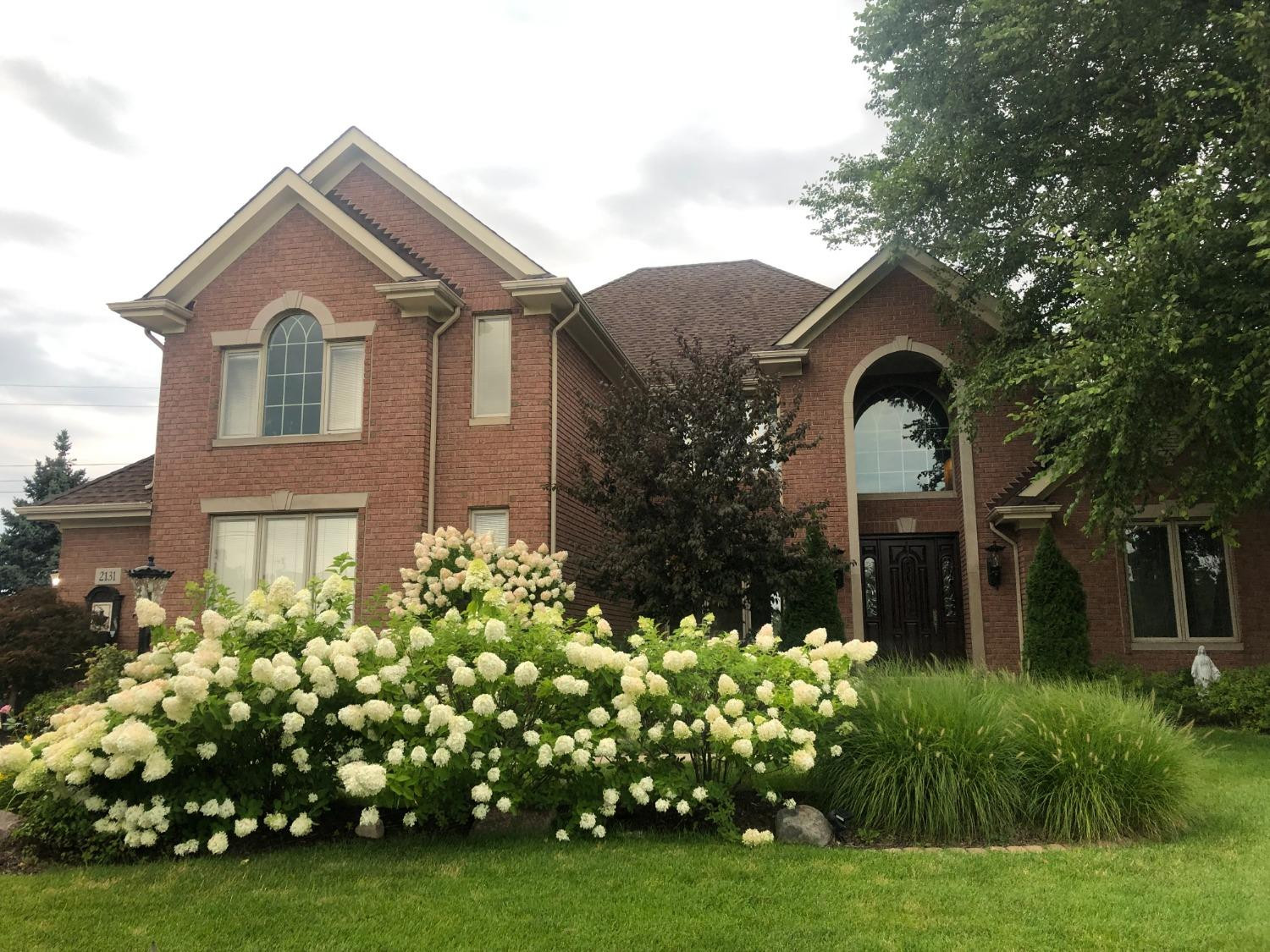 a front view of a house with a garden