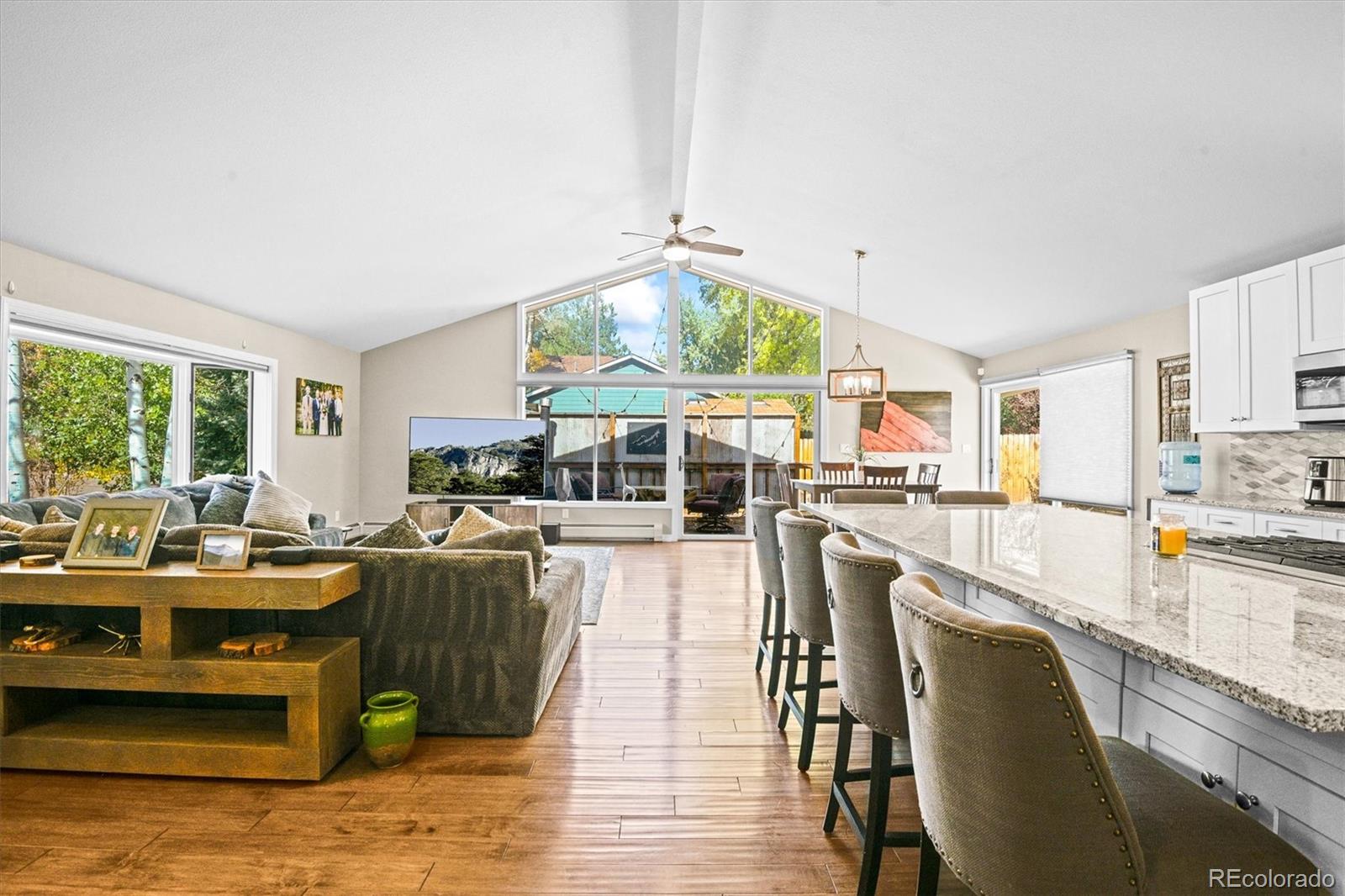 a dining hall with stainless steel appliances granite countertop a stove and a living room view