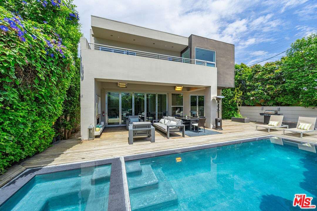 a view of backyard of house with outdoor seating and green space