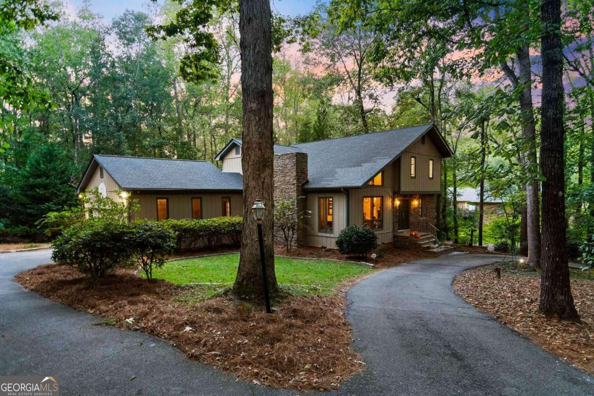 a front view of a house with a yard and trees