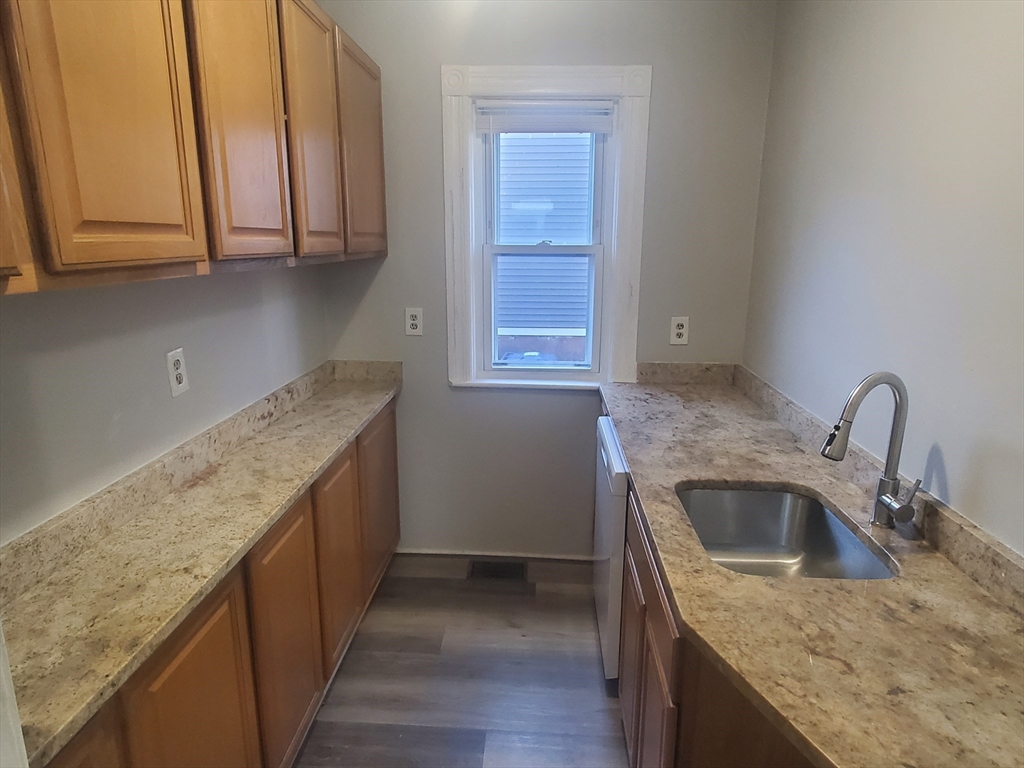 a kitchen with granite countertop a sink and a stove