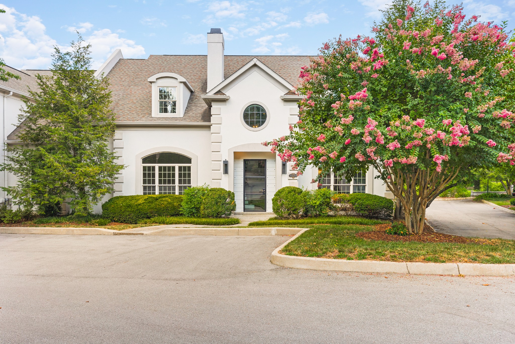 a front view of a house with yard and green space