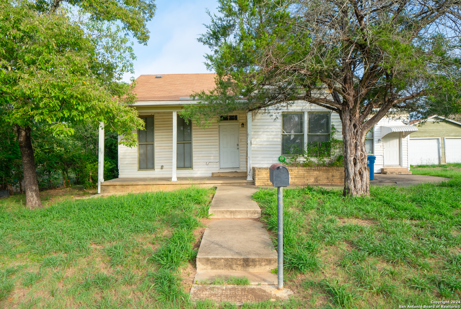 a front view of a house with yard and green space