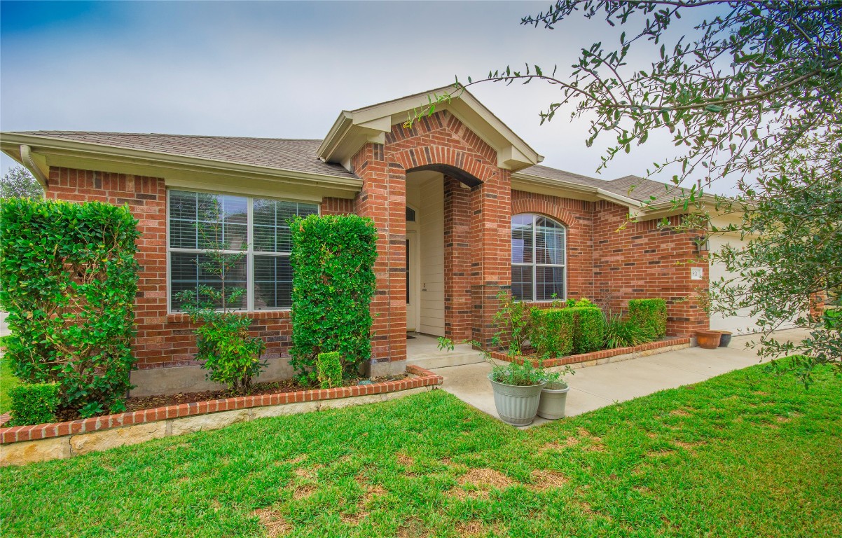 a front view of a house with a yard and potted plants