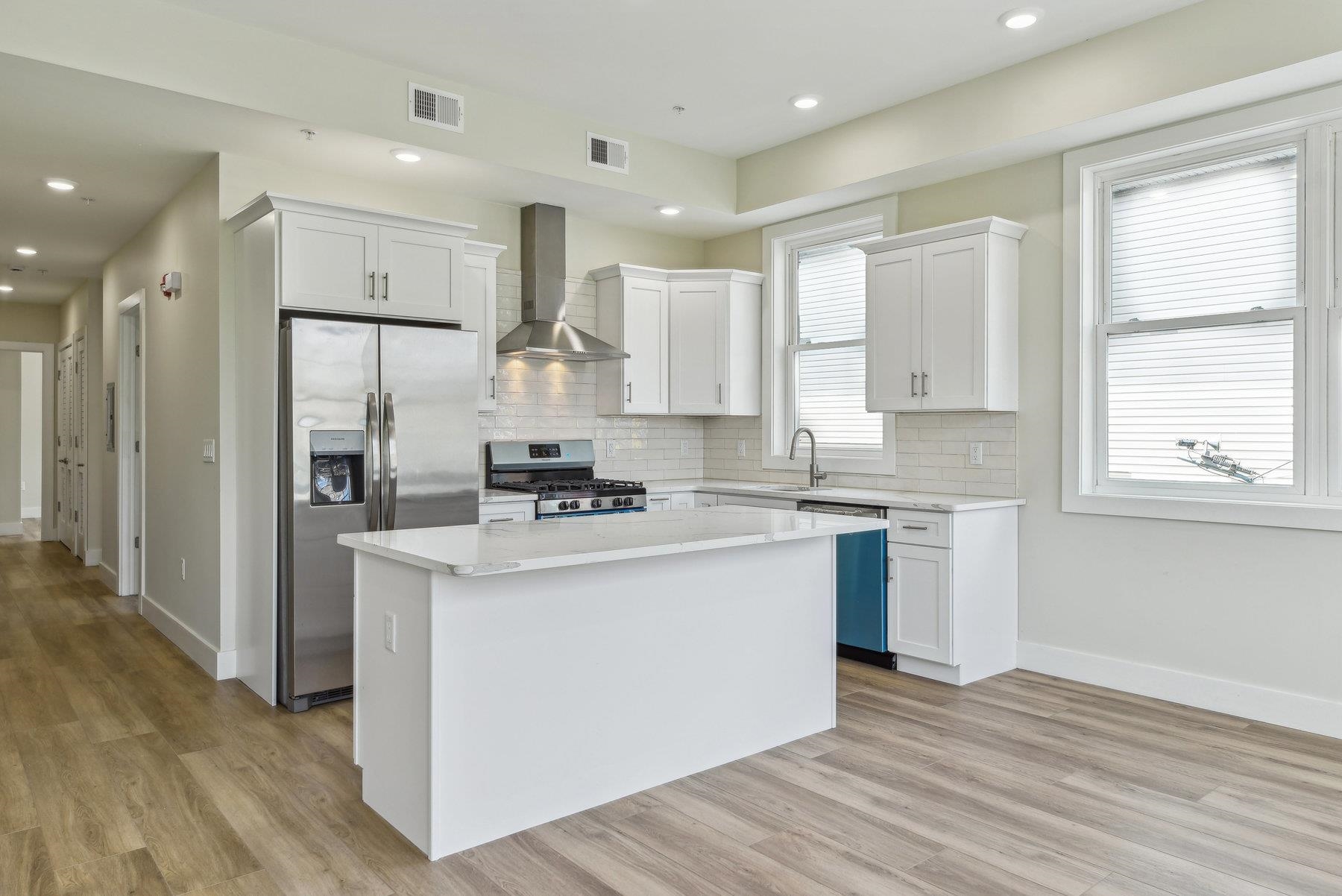 a kitchen with stainless steel appliances sink refrigerator and microwave