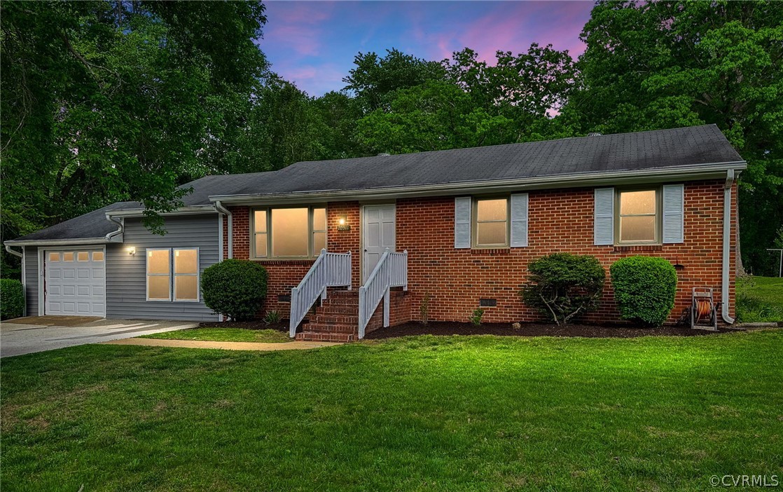 a front view of a house with a yard and green space