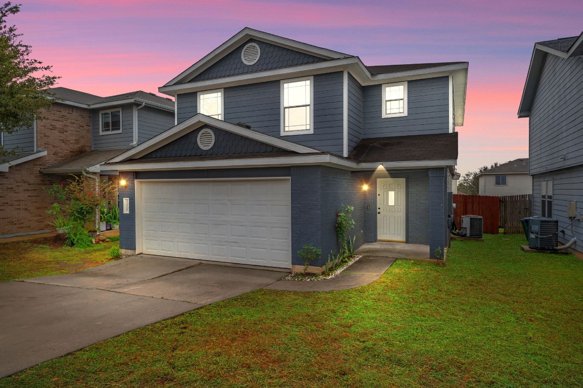 a front view of a house with a yard and garage