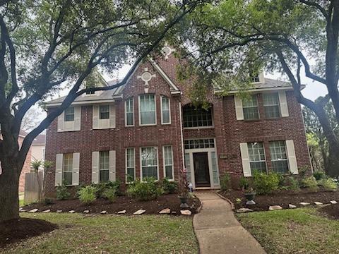 front view of a brick house with a yard