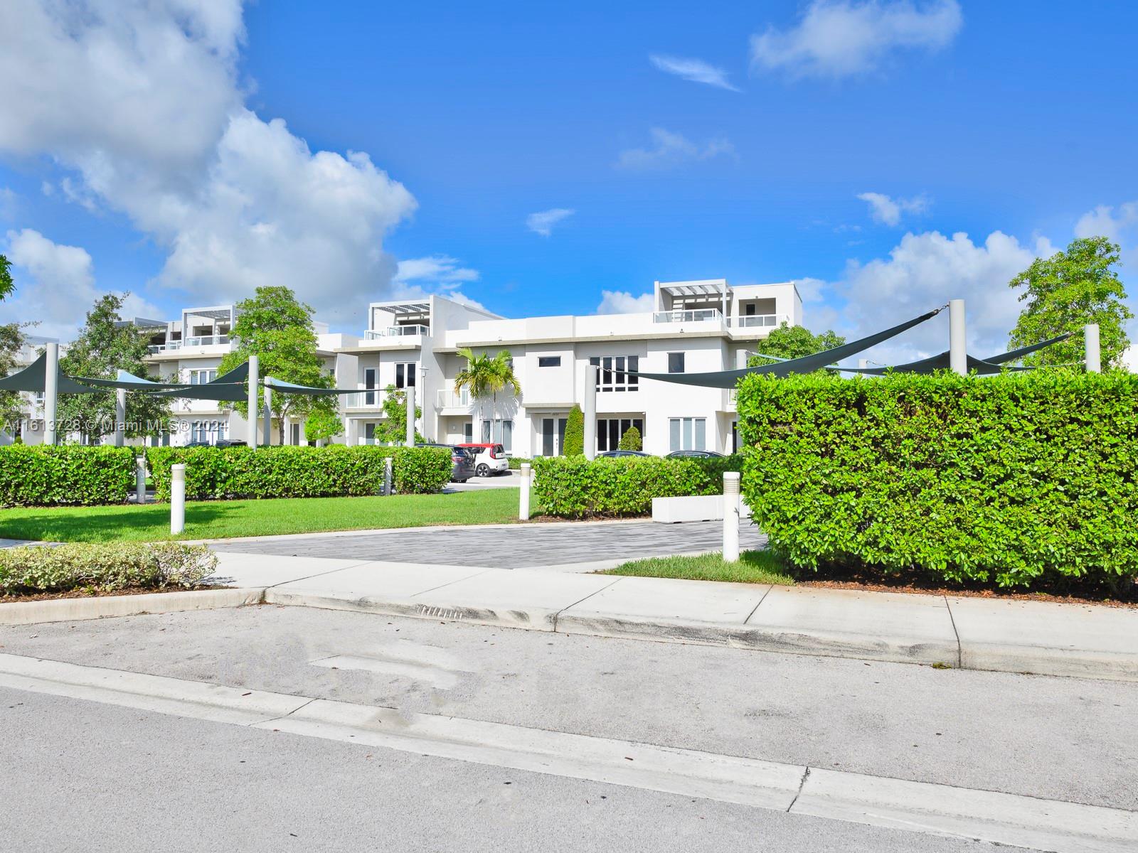 a view of a building with a yard and plants