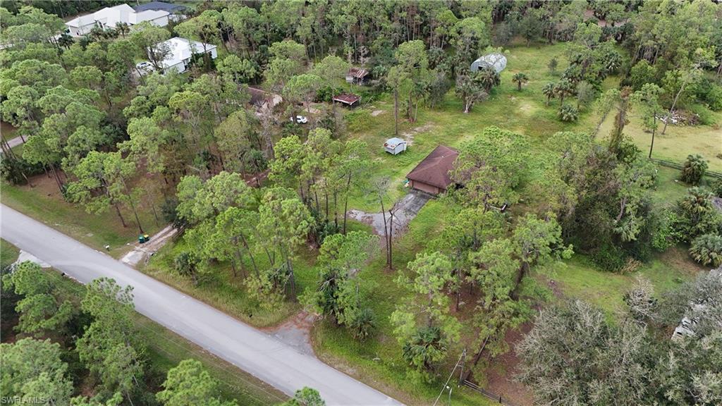 an aerial view of residential houses with outdoor space and trees