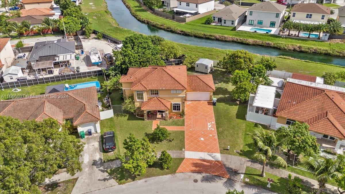 an aerial view of a house with a garden and lake view