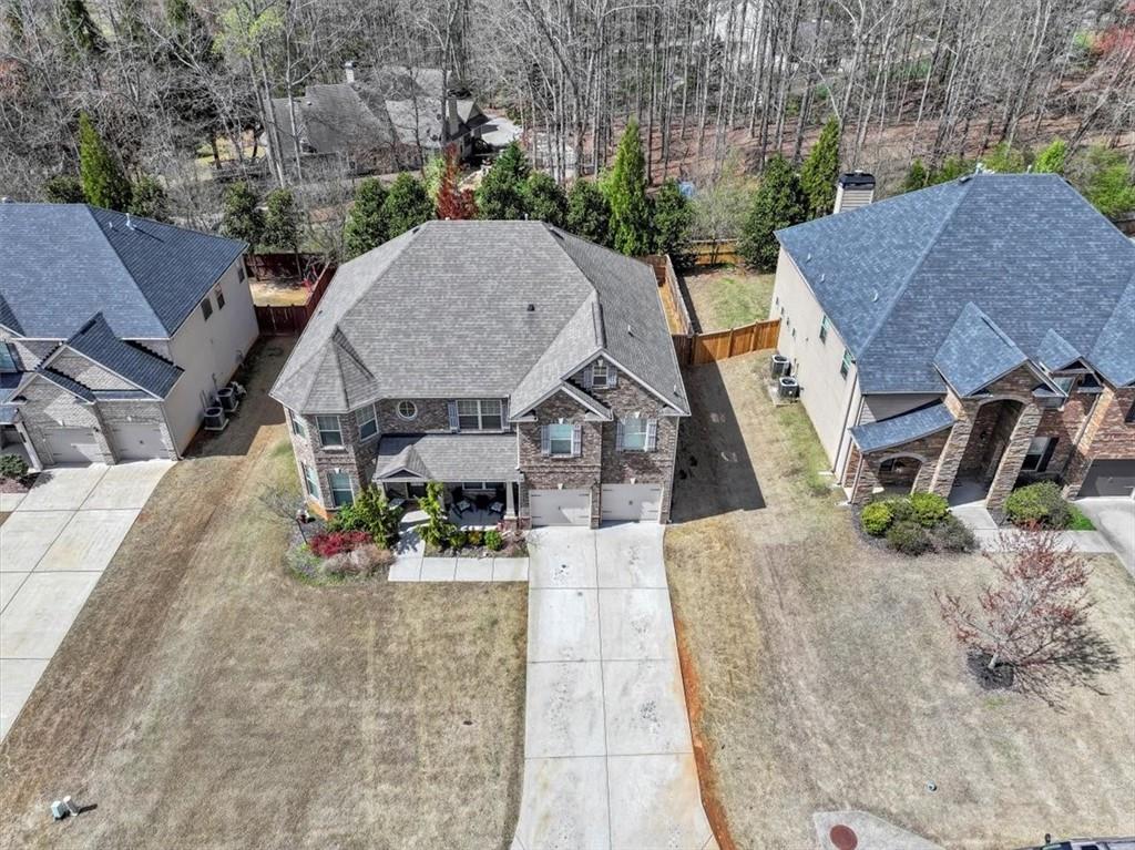 an aerial view of a house with swimming pool and large trees