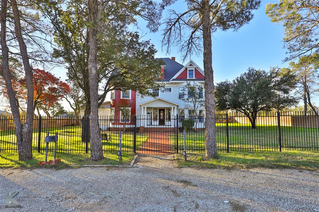 a view of a house with a yard and a large tree