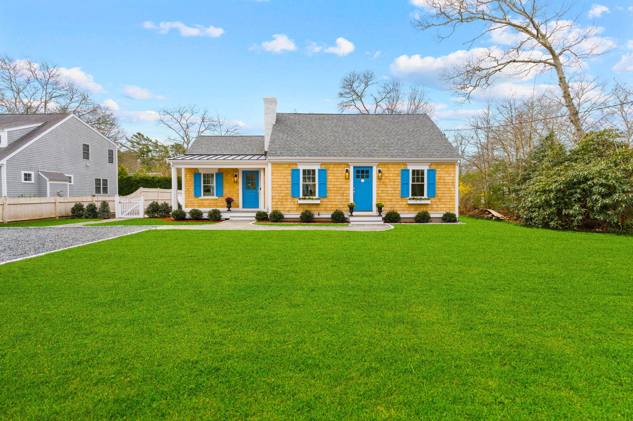 a front view of a house with a garden and trees