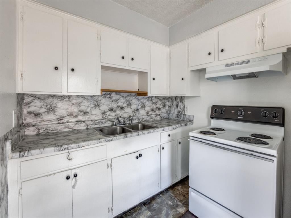 a kitchen with granite countertop white cabinets and white appliances