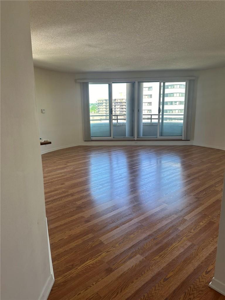 Unfurnished room featuring a textured ceiling and dark wood-type flooring