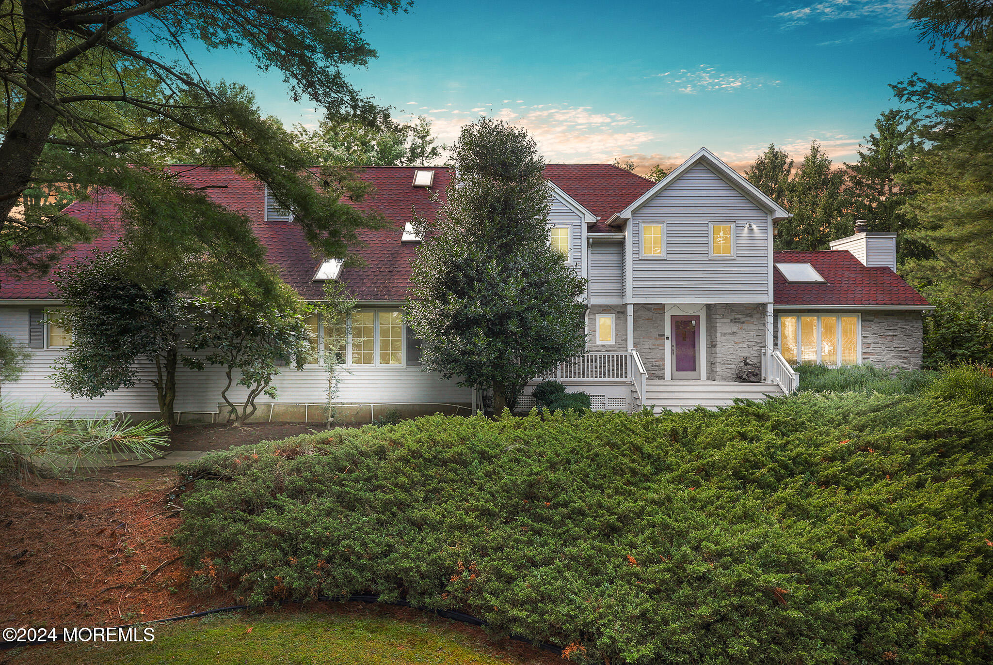 a front view of a house with yard and green space