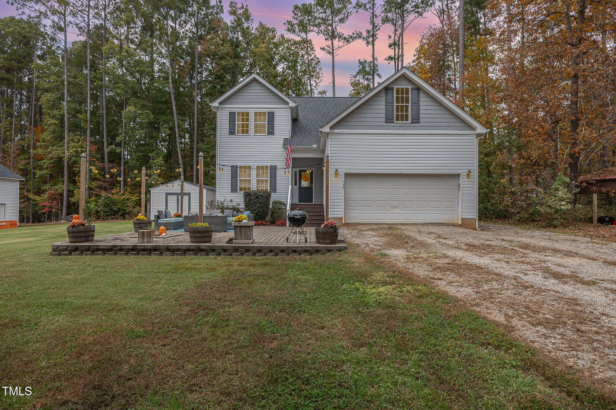 a front view of a house with a yard garage and trees