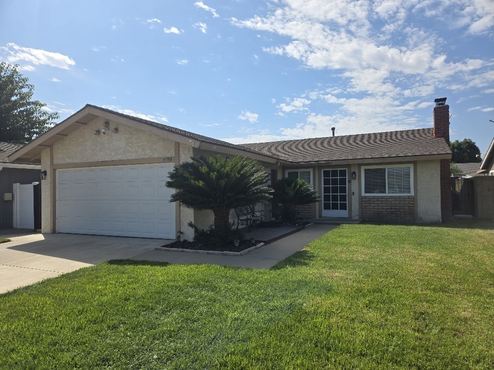 a view of a house with a yard and tree