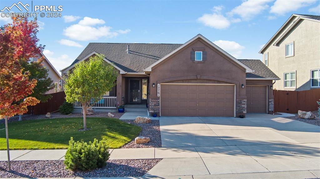 View of front of house featuring beautiful landscaping and a 3-car garage