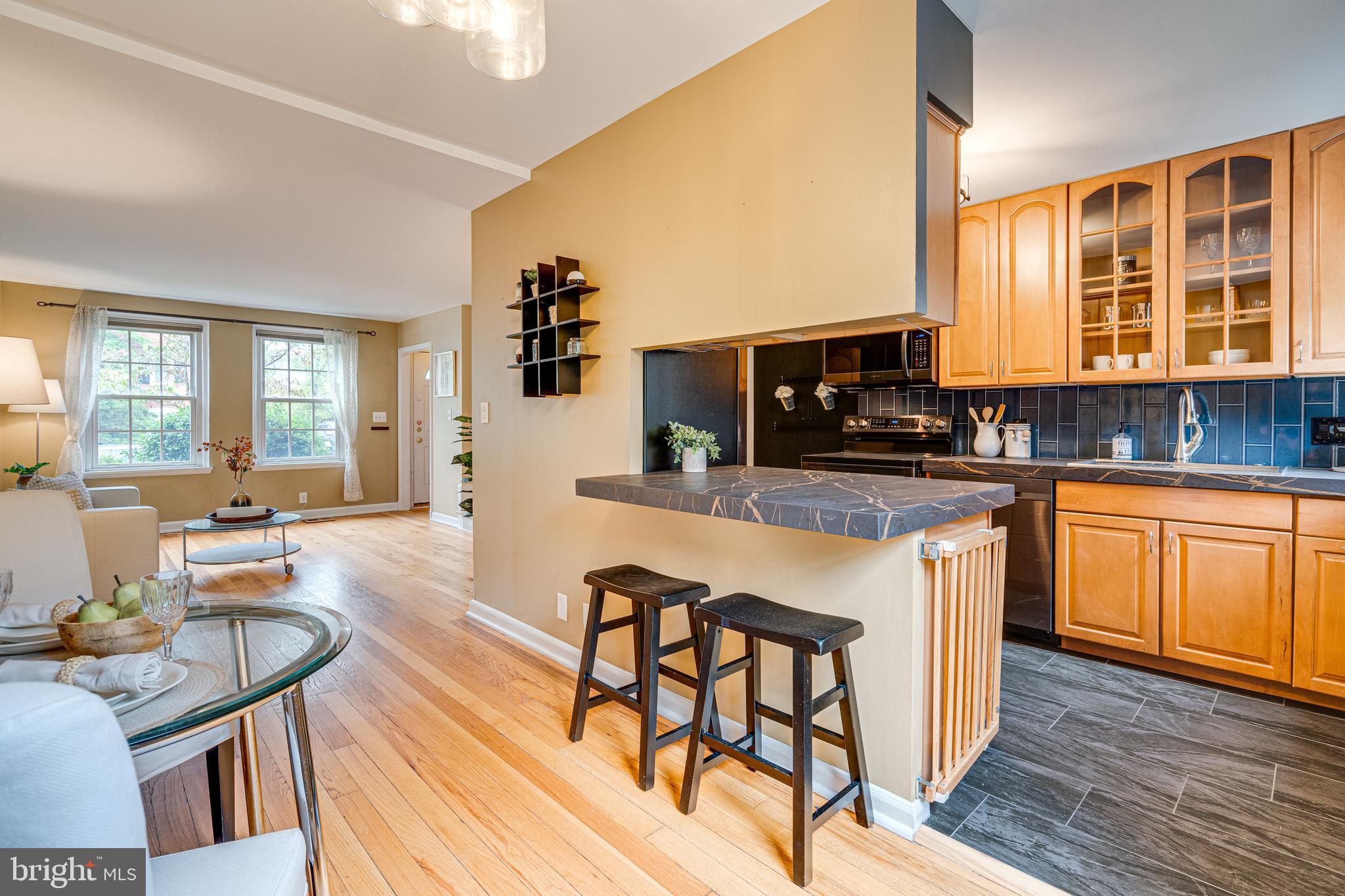 a kitchen with granite countertop a stove a sink a dining table and chairs