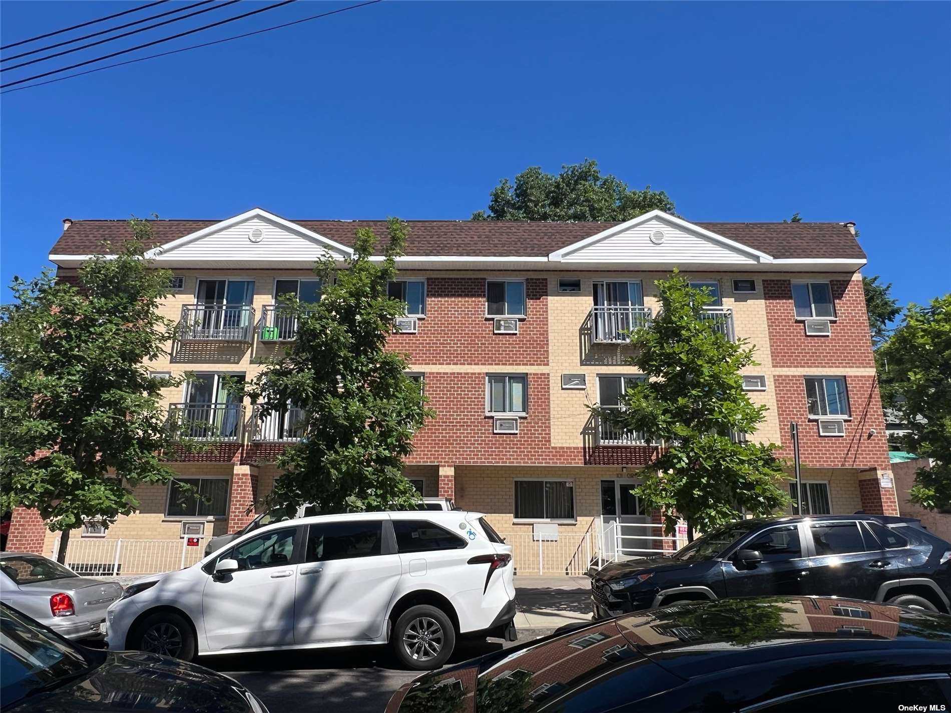 a front view of a house with cars parked